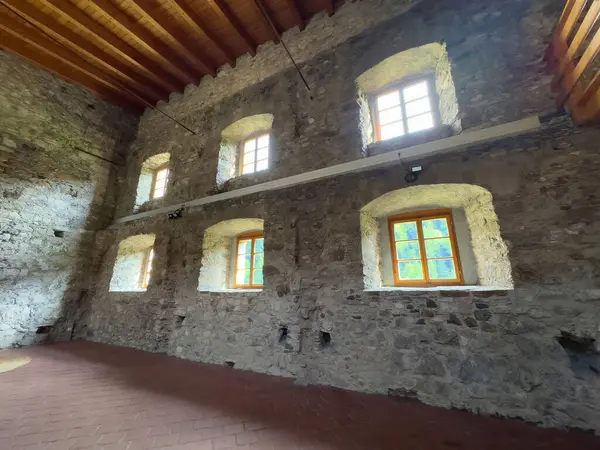 Tarihi binanın ahşap tavanı ve güneşli pencereleri olan taştan bir iç döşeme..