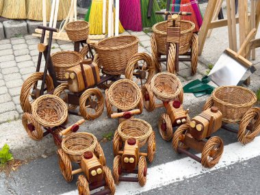 Dışarıda sergilenen oyuncak araç şeklinde el yapımı hasır sepetler..