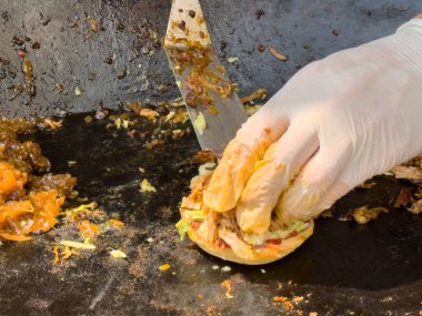 Aşçı lezzetli ızgara sandviç hazırlıyor soğanlı ve ızgara etli..