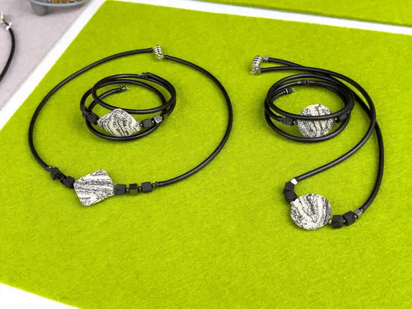 Canlı yeşil arkaplan üzerine kurulu modern siyah ve gümüş mücevher..