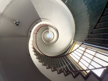 Geometrik desenli ve doğal ışıklandırmalı sarmal merdiven..