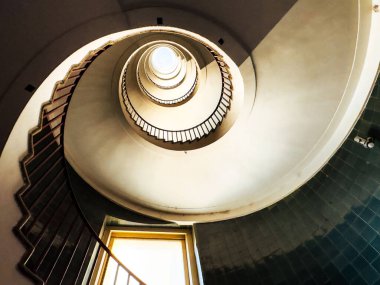 Modern mimari binasının tepesinde ışık olan sarmal merdiven.