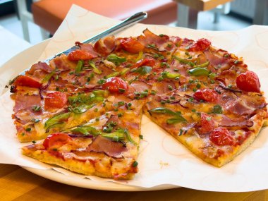 Lezzetli sebze ve jambonlu pizza, taze domates ve yeşil biber..