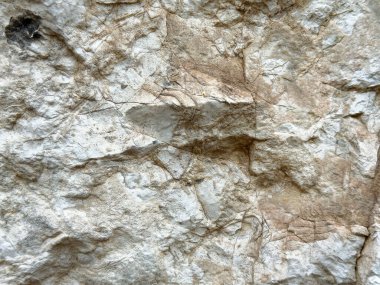 Kireç taşı yüzeyinin pürüzlü dokusu ve doğal desenleri.