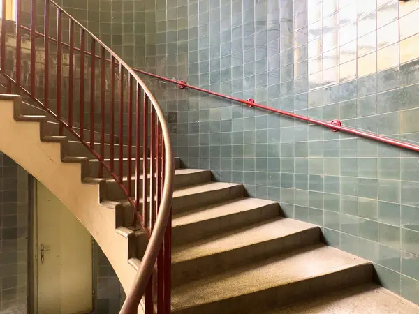 İç döşemesi kırmızı korkuluklu kıvrımlı merdiven..