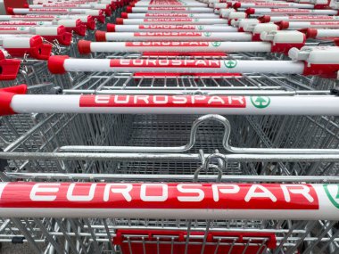 Tarvisio, İtalya - 01 Haziran 2025: Eurospar markalı alışveriş arabaları düzgünce düzenlenmiş, perakende kuruluşu ve tüketici erişilebilirliğini ön plana çıkarıyor