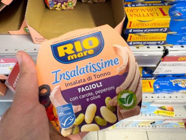 Tarvisio, İtalya - Haziran 01, 2025: Renkli bir markette fasulye, havuç ve zeytin içeren RIO mare Insalatime ton balığı salatası paketi sergileniyor
