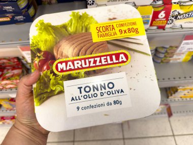 Tarvisio, İtalya - 01 Haziran 2025: Maruzzella zeytinyağı ambalajı elinde, süpermarket raflarında çeşitli ürünlerle çevrili