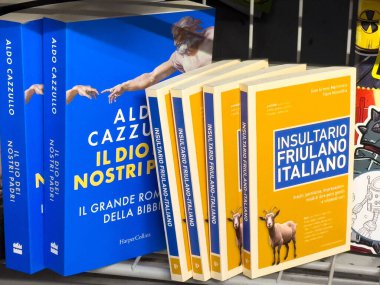 Tarvisio, İtalya - 01 Haziran 2025: Aldo Cazzullo 'nun kitapları renkli kapakları ve İtalyan edebiyatı ve kültürü temalarını vurgulamak üzere bir rafa dizildi