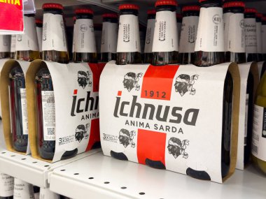 Tarvisio, İtalya - 01 Haziran 2025: Ichnusa bira şişeleri bir süpermarket rafında düzenli olarak düzenlenerek, bu popüler Sardunya birasının eşsiz markasını ve renklerini vurguluyor