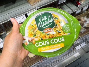 Tarvisio, İtalya - 01 Haziran 2025: Hand, Beretta Viva La Mamma kuskus paketini market koridorunda renkli gıda vitriniyle sunuyor