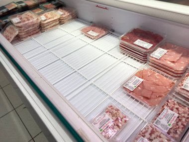 Tarvisio, İtalya - 01 Haziran 2025: Süpermarket dondurucusu, popülerliği ve taze et ürünlerine olan talebi vurgulayan dikkat çekici boş alanlarla çeşitli paketlenmiş etler sunuyor