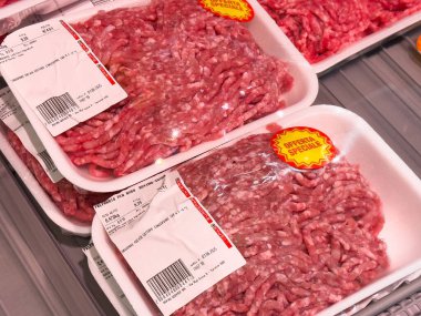 Tarvisio, İtalya - 01 Haziran 2025: Market buzdolabındaki kıyma paketleri, parlak kırmızı et ve müşteri çekimleri için promosyon etiketleri