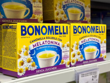 Tarvisio, İtalya - 01 Haziran 2025: Bonomelli papatya çayı ve süpermarket raflarında sergilenen melatonin kutuları renkli ambalajları ve bitkisel faydaları vurguluyor
