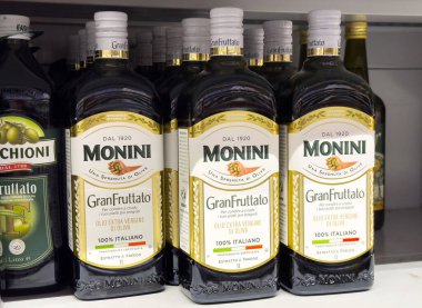 Tarvisio, İtalya - 01 Haziran 2025: Monini GranFruttato ekstra bakire zeytinyağı şişeleri süpermarket raflarında sergilenmiş, İtalyan işçiliği ve kalitesini vurguluyor