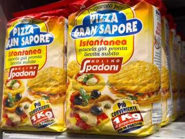 Tarvisio, İtalya - 01 Haziran 2025: Molino Spadoni 'nin anlık pizza karışımı paketleri, renkli markalaşma ve ürün detaylarıyla süpermarket raflarında belirgin bir şekilde sergileniyor