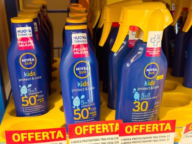 Tarvisio, İtalya - 01 Haziran 2025: NIVEA Sun çocukları bir rafa dizilmiş güneş kremi şişeleri, renkli ambalajlar ve güneş bakımı için özel teklifler