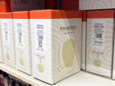 Tarvisio, İtalya - 01 Haziran 2025: Rauscedo şarap kutuları bir rafa dizilmiş, eşsiz markalaşma ve tasarım unsurlarını vurguluyor