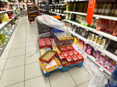 Tarvisio, İtalya - 01 Haziran 2025: Market koridorundaki bir palette parlak renkler ve kolay erişim için organize edilmiş bir düzen içeren meşrubat kutuları