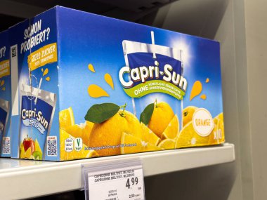 Tarvisio, İtalya - 01 Haziran 2025: Capri-Sun portakal suyu kutusu açık bir şekilde bir süpermarket rafında sergileniyor, renkli tasarımı ve ferahlatıcı cazibesi vurgulanıyor