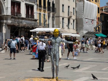 Venedik, İtalya - 24 Haziran 2025: Venedik 'te Joseph Bezos' un düğününü protesto eden bir sanatçı, kalabalık kalabalığın ve tarihi binaların arasında bir dolar banknot kostümü giyiyor.