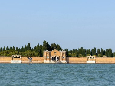 Venedik, İtalya - 25 Haziran 2025: Venedik 'te San Michele Adası, ağaçlar ve sakin sularla çevrili, keşif için sakin bir atmosfer sunan güzel bir mimariye sahiptir.