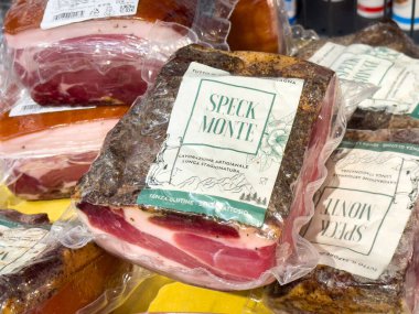 Venedik, İtalya - 25 Haziran 2025: Speck Monte sanatsal iyileştirilmiş et, parlak sarı bir yüzeye güzelce paketlenmiştir, zengin dokusunu ve markasını vurgular.