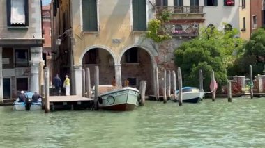 Venedik 'in tarihi rıhtımında seyrüsefer yapan yolcu feribotuyla manzaralı kanal yolculuğu.
