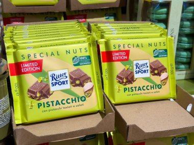 Venedik, İtalya - 23 Haziran 2025: Ritter Sport şam fıstıklı çikolataları, renkli ambalajlarını ve özel baskı cazibelerini vurgulamak için market raflarına yerleştirildi