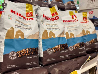 Venedik, İtalya - 23 Haziran 2025: Kimbo kahve poşetleri, orta pişmiş rosto ve renkli ambalajlar eşliğinde bir market rafına yerleştirildi