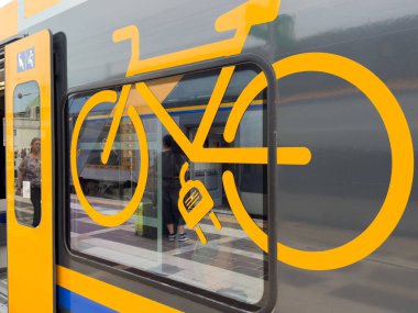 Venedik, İtalya - 23 Haziran 2025: Elektrikli tren penceresindeki bisiklet sembolü kentsel çevrede yenilikçi ulaşım tasarımını ön plana çıkarıyor, sürdürülebilir seyahat seçeneklerini destekliyor