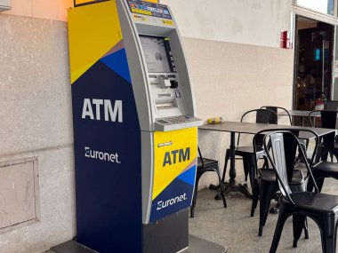 Venedik, İtalya - 23 Haziran 2025: Çağdaş bir kafede yer alan Euronet ATM, müşterilerin bankacılık hizmetlerine erişebileceği oturma alanlarıyla çevrili