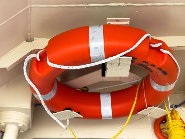 Venedik, İtalya - 23 Haziran 2025: Parlak turuncu yaşam şamandırası, deniz ortamları ve kurtarma hazırlıkları için gerekli güvenlik ekipmanlarını vurgulayarak duvarda sergilendi