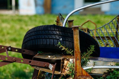 Tarlada lastiği olan paslı tarım ekipmanları.