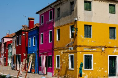 Burano, İtalya - 25 Haziran 2025: Burano, İtalya 'da kanal boyunca canlı evler, eşsiz bir mimari ve renkli cephelerin ön plana çıkarılması