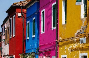 Burano, İtalya - 25 Haziran 2025: Burano, İtalya 'da canlı evler, parlak renkler ve eşsiz mimari, adada büyüleyici bir atmosfer yaratıyor.
