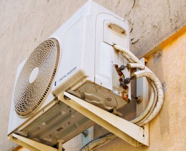 Burano, İtalya - 25 Haziran 2025: Kapalı alan sıcaklıklarının korunması için gerekli kompresör ve boruların sergilendiği havalandırma ünitesi duvara monte edildi