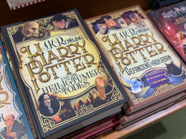 Villach, Avusturya - 01 Temmuz 2025: Harry Potter kitapları ahşap rafta düzenlendi, renkli kapaklar ve detaylı çizimler, fantezi edebiyatı hayranları için mükemmel