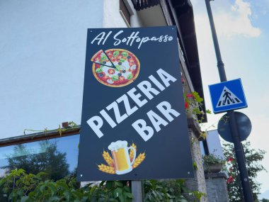 Villach, Avusturya - 01 Temmuz 2025: Pizzacı Al Sottopasso yeşil ve sokak tabelalarıyla çevrili canlı pizza ve bira grafikleri imzaladı