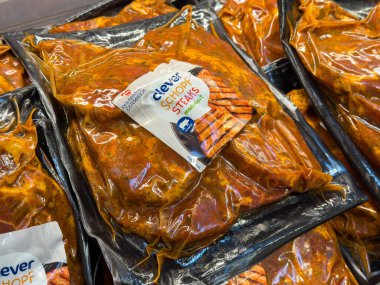 Villach, Avusturya - 01 Temmuz 2025: Vakumlu poşetlerde marine edilmiş domuz bifteği, zengin renkler ve çekici dokular, yemek ve ızgara yapmak için mükemmel