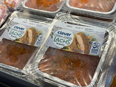 Villach, Avusturya - 01 Temmuz 2025: Akıllı somon ambalajı, ızgara için ideal taze otlar içeriyor, aşçılık ilhamı ve yemek hazırlığı için bir süpermarkette sergileniyor