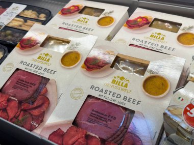 Villach, Avusturya - 01 Temmuz 2025: BILLA kavrulmuş sığır eti paketleri, dereotu hardal sosu ve kaliteli et kalitesini ön plana çıkaran bir markette düzenlenmiştir