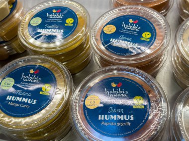 Villach, Avusturya - 01 Temmuz 2025: Habibi 's Haven' daki çeşitli humus kapları mango köri ve kırmızı biber aromalı, besleyici yemekler ve atıştırmalıklar için ideal