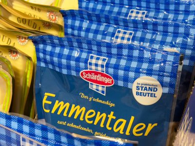 Villach, Avusturya - 01 Temmuz 2025: Schardinger Emmentaler peynir paketleri rafa dizildi, parlak mavi ambalajlar ve müşteriler için cazip markalar sergilendi