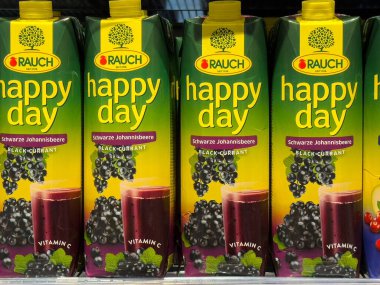 Villach, Avusturya - 01 Temmuz 2025: Rauch Happy Day kara üzüm suyu kutuları mağaza raflarında sergileniyor, parlak renkler ve müşteriler için çekici tasarımlar sunuluyor