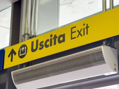 Maestre, İtalya - 25 Haziran 2025: Açık sarı Uscita Çıkış işareti, kolay navigasyon için çağdaş mimaride net bir yön sağlıyor
