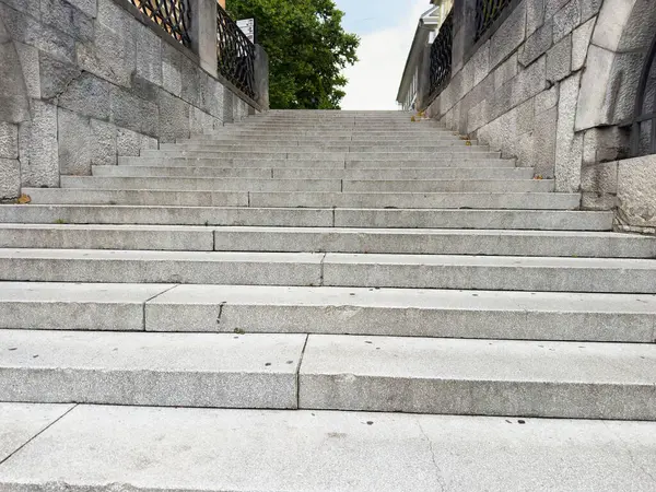 Ağaçlar ve süslü metal parmaklıklarla tarihi kemer yoluna çıkan taş merdiven..