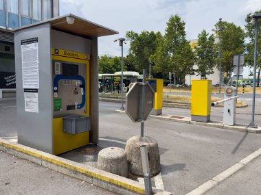 Ljubljana, Slovenya - 06 Temmuz 2025: Arkaplanda ağaçlar ve toplu taşıma araçları bulunan şehir çevresindeki kentsel park ödeme makinesi