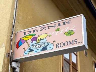 Ljubljana, Slovenya - 06 Temmuz 2025: Deznik odalarının canlı tabelası şemsiyeli çizgi film karakterini sergiliyor ve konuklar için hoş bir ortam yaratıyor