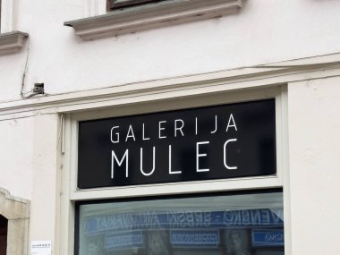 Ljubljana, Slovenya - 06 Temmuz 2025: Çağdaş tasarım ve davetkar atmosferi yansıtan Galerija Mulec tabelası kentsel alanda belirgin bir şekilde sergilendi